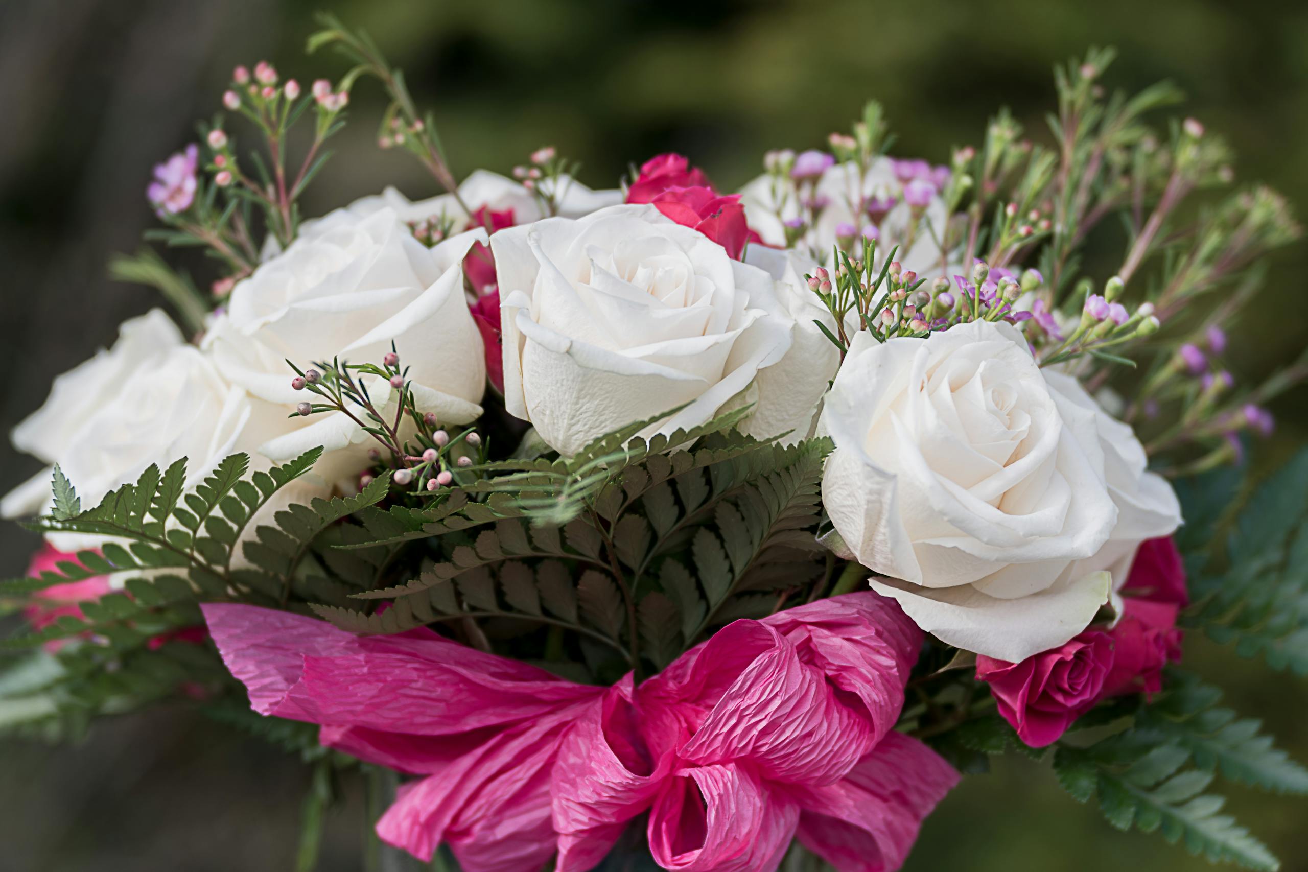 Tender bouquet of roses and small wildflowers in daylight